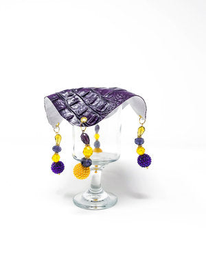 purple crocodile skin textured drink cover with yellow and purple beads on glass