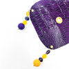 purple crocodile skin textured drink cover with yellow and purple beads off the glass
