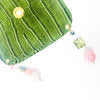 green crocodile skin textured drink cover with clear and pink beads off the glass