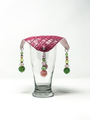 pink crocodile skin textured drink cover with green and pink beads on glass