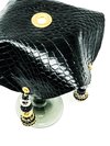 black crocodile skin textured drink cover with white and crimson beads on glass top view