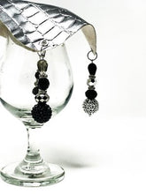 Matte black beads with silver beads dangle off each corner of the drink cover